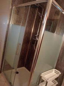 a shower with a glass door and a stool at La Cabane du Berger & son terrain de pétanque in Torsiac +40 photos