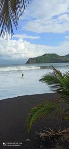 a person is in the water on the beach at Hostal Tortuga Surf in Tonosí