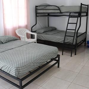 a bedroom with two bunk beds and a ladder at Hostal Tortuga Surf in Tonosí +11 photos