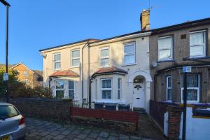 a house with a bench in front of it at Chapel Road Cosy Rooms & Studios in Hounslow