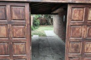 un ingresso a un garage con due porte in legno di Casa Alina a Santa Clara del Mar