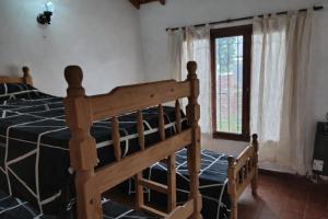 una camera da letto con un letto di legno e una finestra di Casa Alina a Santa Clara del Mar