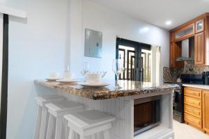 een keuken met een aanrecht met wijnglazen erop bij The Dorset on Ashby in Chaguanas Village