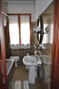 un bagno con lavandino, WC e vasca di Simo House a Follonica