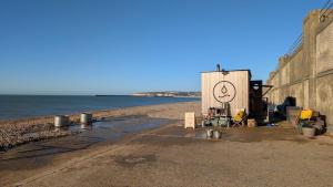 un bâtiment avec un visage souriant peint dessus sur la plage dans l'établissement Seaford Snug, à Seaford