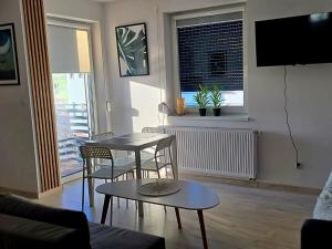 een woonkamer met een tafel en stoelen en een televisie bij Apartament Studio Centrum in Człuchów
