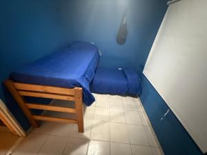 a blue room with a bed and a stool at Casa quinta in Dolores