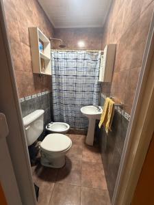 a small bathroom with a toilet and a sink at Casa quinta in Dolores