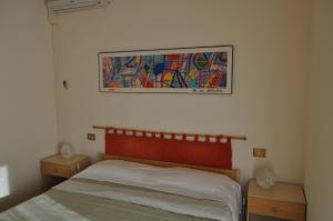 una camera da letto con un letto e un quadro sul muro di Simo House a Follonica