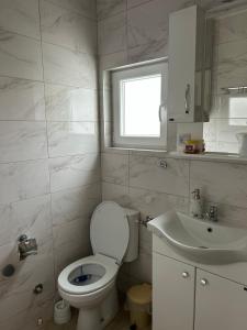 a bathroom with a toilet and a sink and a window at Verina kuća in Kosjerić +38 photos