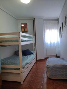 sypialnia z dwoma łóżkami piętrowymi i oknem w obiekcie El Sueño del Maestro w mieście Suances