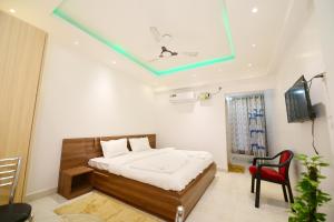 a bedroom with a bed and a red chair at Airport residency hotel ranchi in Arambol