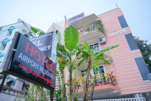 a pink building with a sign in front of it at Airport residency hotel ranchi in Arambol