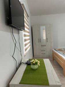 a living room with a tv and a table with flowers on it at Verina kuća in Kosjerić