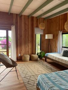 a bedroom with wooden walls and a bed and a lamp at Mar de Fondo in La Pedrera