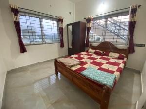ein Schlafzimmer mit einem Bett in einem Zimmer mit Fenstern in der Unterkunft Jk homestay Mysore in Mysore