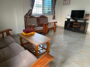 ein Wohnzimmer mit Sofa und Tisch in der Unterkunft Jk homestay Mysore in Mysore