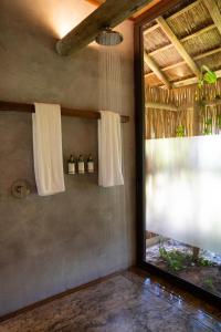 a bathroom with white curtains and a window at Primitivo Hotel & Villas in Passo de Camarajibe +11 photos
