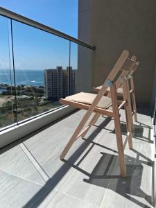 een houten stoel bovenop een balkon bij doca brisa in Santa Marta