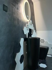 a bathroom with a black toilet and a mirror at A-frame Boema in Cîmpu lui Neag +28 photos