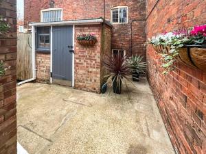 a garage with a door and a brick wall at Tap Cottage in Burgh le Marsh
