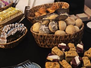 een tafel met manden vol gebak en koekjes bij Black Swan House, Old Town in Gdańsk