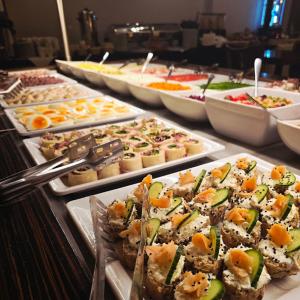 een buffet met veel verschillende soorten eten bij Black Swan House, Old Town in Gdańsk