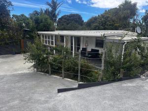 a house with a fence in front of it at Kauri Cabin in Gisborne