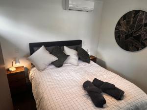 a bedroom with a bed with black towels on it at Kauri Cabin in Gisborne