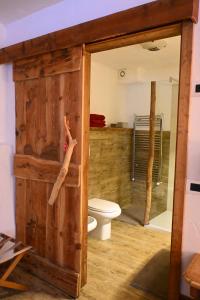 bagno con servizi igienici e porta in legno di APPARTAMENT La locanda nel bosco a Mezzana Altre 24 foto