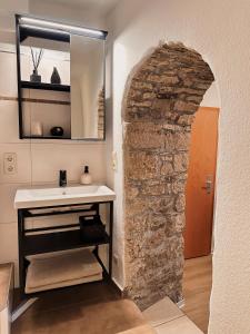 a bathroom with a sink and a stone wall at Ferienwohnung Querfurt in Querfurt