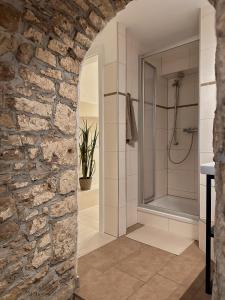 a bathroom with a stone wall and a shower at Ferienwohnung Querfurt in Querfurt