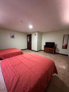 een hotelkamer met twee bedden en een televisie bij HOTEL MATAMOROS frente al consulado in Matamoros