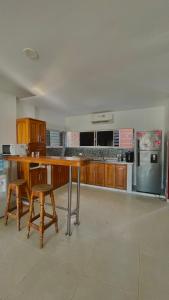 a kitchen with a wooden table and a refrigerator at Alojamientos Fredys in Santa Cruz de Mompox