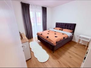a bedroom with a bed and a table and a window at Apartman Maras in Posušje