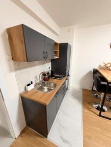 a small kitchen with a sink and a desk at Apartman Maras in Posušje
