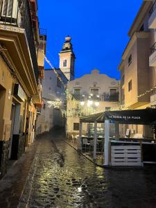 een stadsstraat met een klokkentoren op de achtergrond bij La Llum de Serra in Serra