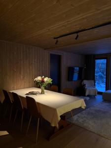 a dining room table with a vase of flowers on it at Exclusive Cabin with Sauna in Fossmo