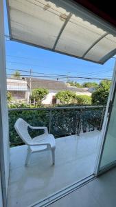 a white chair sitting on the balcony of a house at Alojamientos Fredys in Santa Cruz de Mompox
