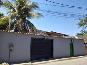 a garage with a green door and a palm tree at Light House Pousada in Paraty