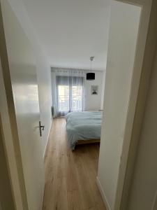 una camera da letto con un letto e una finestra di Grand T2 cosy à deux pas de Bordeaux a Cenon