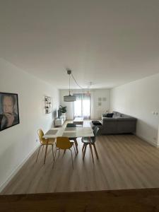 un soggiorno con tavolo, sedie e divano di Grand T2 cosy à deux pas de Bordeaux a Cenon