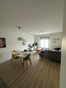un soggiorno con un tavolo e un divano di Grand T2 cosy à deux pas de Bordeaux a Cenon Altre 7 foto