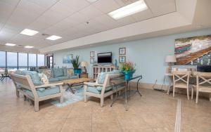 a living room with a couch and chairs and a tv at Phoenix East 1211 in Orange Beach
