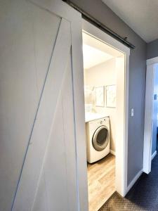 eine Tür zu einer Waschküche mit einer Waschmaschine in der Unterkunft Modern Lake City Getaway in Penticton