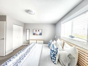 ein Schlafzimmer mit einem großen Bett mit blauen und weißen Kissen in der Unterkunft Modern Lake City Getaway in Penticton