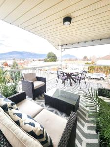 eine Terrasse mit Sofas, einem Tisch und Stühlen in der Unterkunft Modern Lake City Getaway in Penticton