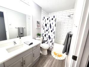 ein Badezimmer mit Waschbecken, Toilette und Dusche in der Unterkunft Modern Lake City Getaway in Penticton + 18 Fotos