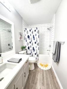 ein weißes Badezimmer mit Toilette und Dusche in der Unterkunft Modern Lake City Getaway in Penticton