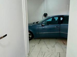a blue car parked in a room with marble floors at VASKO Luxury Suites 4 in Siátista
